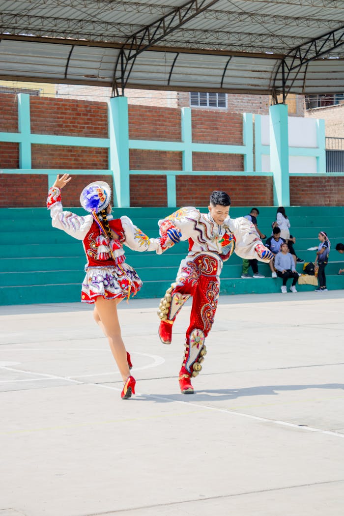 Couple performing traditional dance in colorful costumes outdoors in Peru.